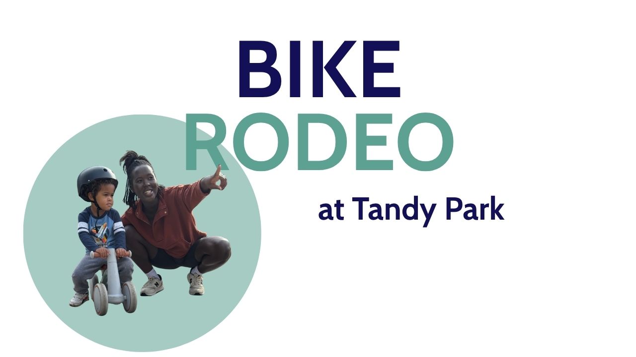 A mother is with her young child, who is sitting on a balance bike. The mother is pointing up to where the graphic says Bike Rodeo at Tandy Parl